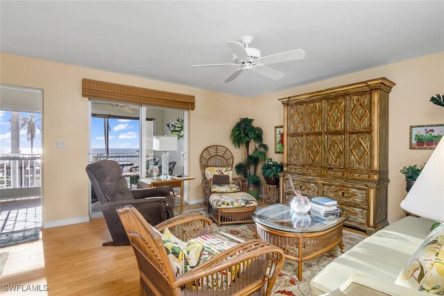 living room with ceiling fan and light hardwood / wood-style flooring