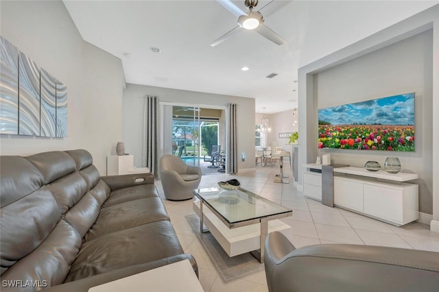 tiled living room featuring ceiling fan with notable chandelier