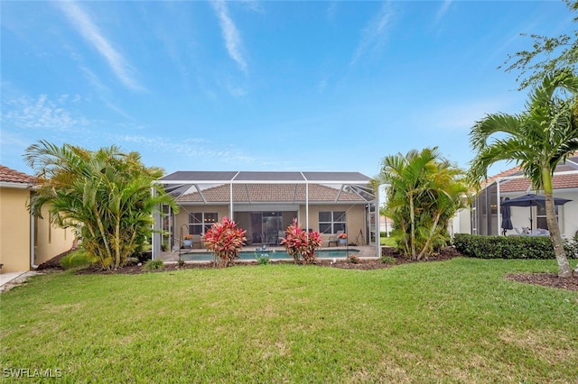 back of house with a lawn and a lanai