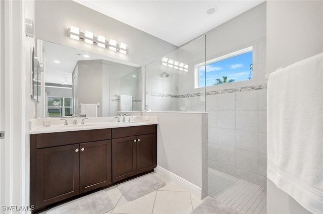 bathroom with tile patterned flooring, vanity, and tiled shower