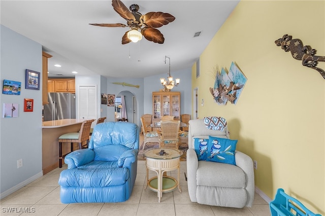 sitting room with ceiling fan with notable chandelier and light tile patterned flooring