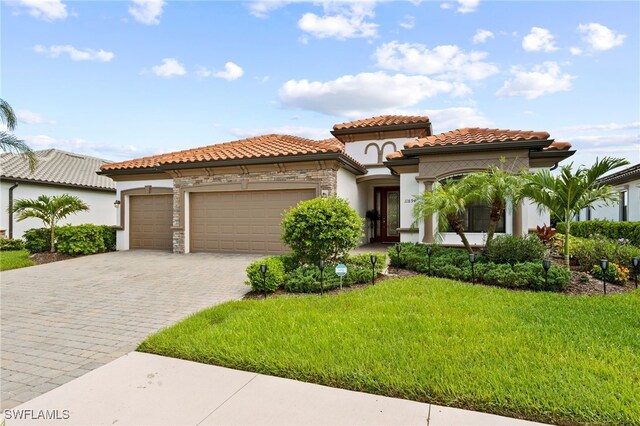 mediterranean / spanish-style home with a front yard and a garage