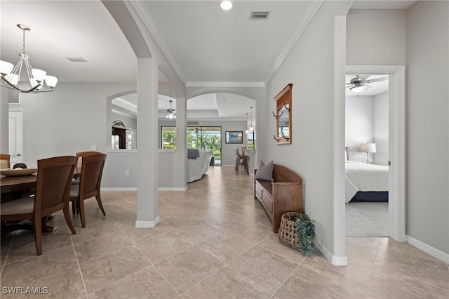 entryway with ornamental molding, ceiling fan with notable chandelier, and light tile patterned flooring