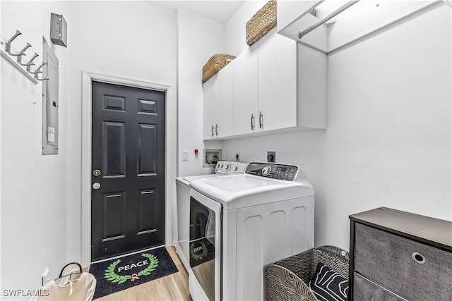 laundry area with cabinets, hardwood / wood-style floors, and independent washer and dryer