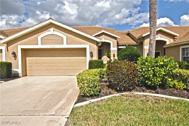 ranch-style home with a garage, concrete driveway, and stucco siding