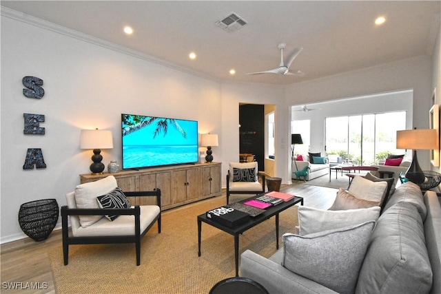 living area featuring ceiling fan, light wood-style floors, recessed lighting, and crown molding