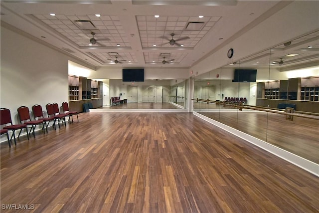 workout room with a ceiling fan, visible vents, and wood finished floors