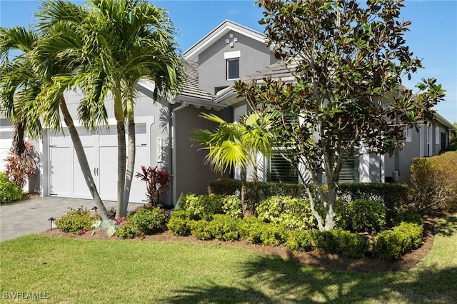 view of front of property with a garage and a front lawn