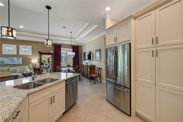 kitchen featuring light stone countertops, appliances with stainless steel finishes, sink, and decorative light fixtures