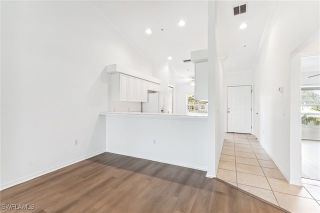 unfurnished living room with crown molding, ceiling fan, and light hardwood / wood-style floors