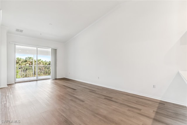 spare room featuring wood-type flooring and ornamental molding