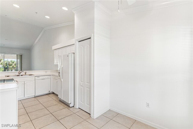 kitchen with ornamental molding, white appliances, vaulted ceiling, sink, and white cabinetry