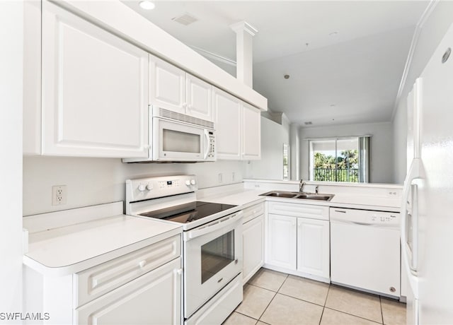 kitchen with kitchen peninsula, white appliances, sink, white cabinetry, and lofted ceiling