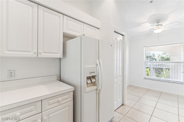 kitchen featuring ornamental molding, ceiling fan, light tile patterned floors, white cabinets, and white fridge with ice dispenser