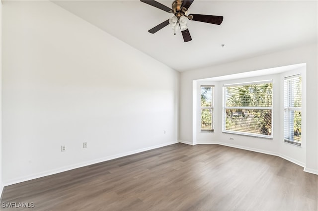 empty room with dark hardwood / wood-style flooring, ceiling fan, and lofted ceiling