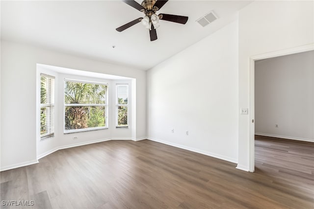 unfurnished room with ceiling fan, dark hardwood / wood-style flooring, and vaulted ceiling