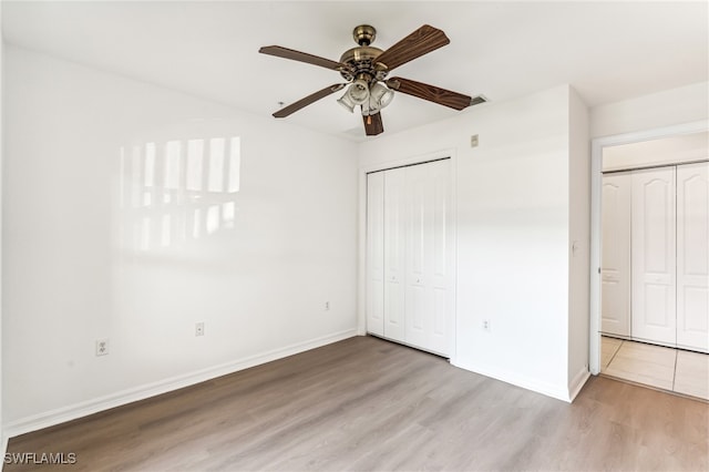 unfurnished bedroom with ceiling fan, light hardwood / wood-style floors, and a closet