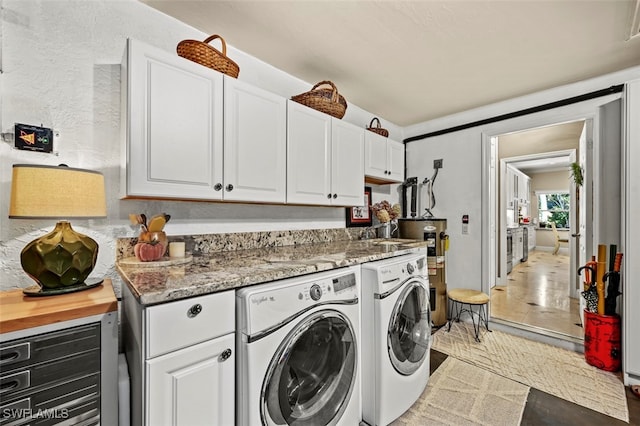 laundry area featuring tile patterned flooring, separate washer and dryer, and cabinets