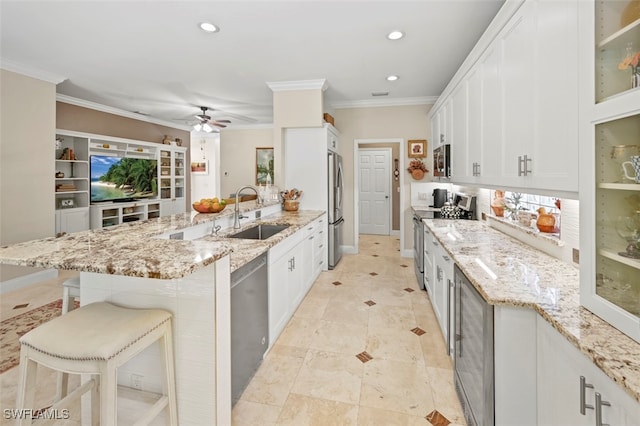 kitchen featuring sink, white cabinetry, stainless steel appliances, and a breakfast bar area