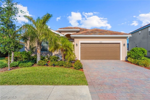 view of front facade featuring a front lawn, decorative driveway, an attached garage, and stucco siding