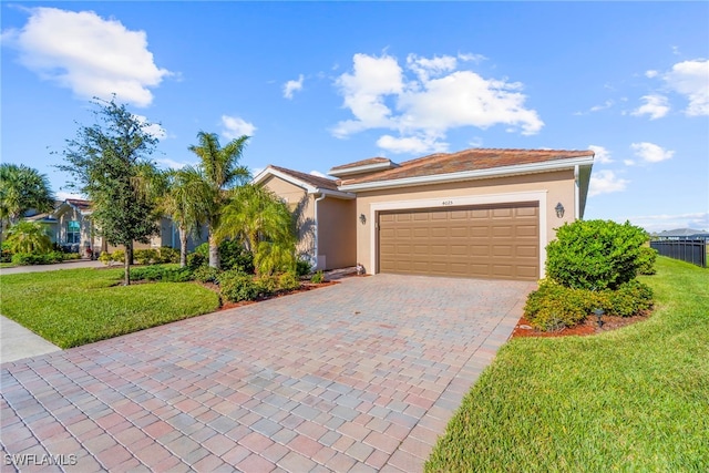 view of front facade with a garage, decorative driveway, a front lawn, and stucco siding