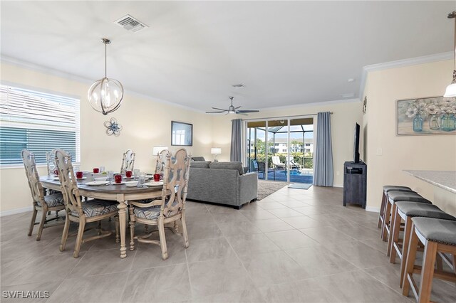 dining space featuring light tile patterned floors, baseboards, visible vents, ornamental molding, and ceiling fan with notable chandelier