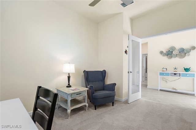 sitting room with ceiling fan, light colored carpet, and french doors