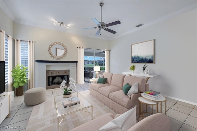 tiled living room featuring ceiling fan, ornamental molding, and a fireplace