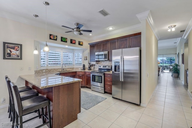 kitchen with kitchen peninsula, hanging light fixtures, light tile patterned flooring, and stainless steel appliances