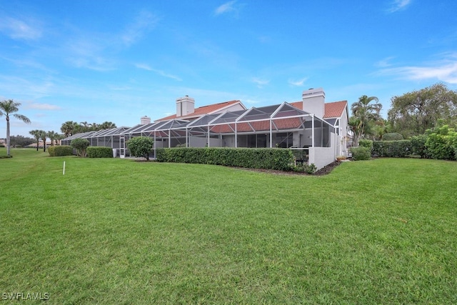 back of house featuring a lanai and a lawn