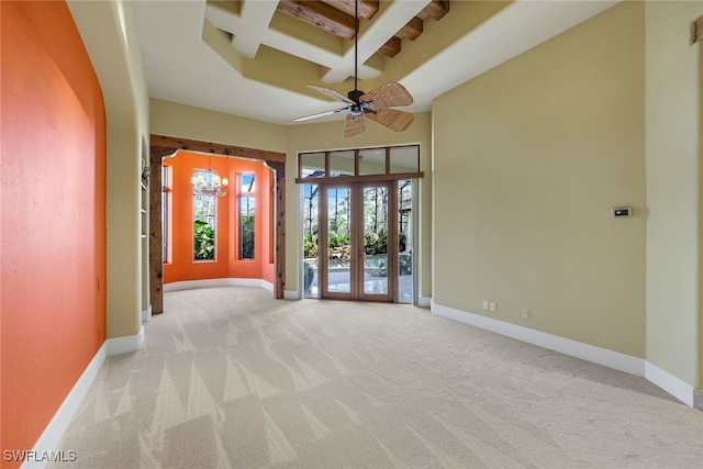 carpeted empty room featuring beamed ceiling, french doors, ceiling fan, and coffered ceiling