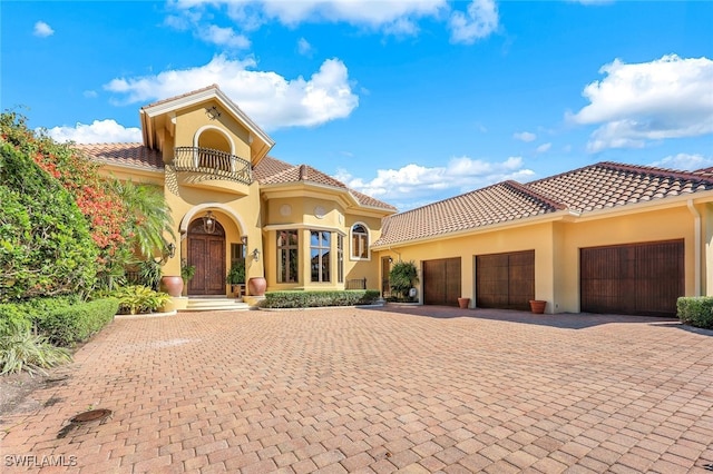 mediterranean / spanish house featuring a garage and a balcony