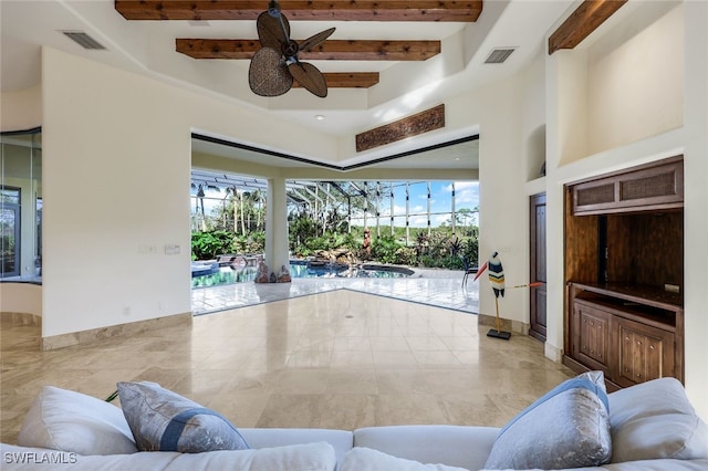 living room featuring beamed ceiling and ceiling fan