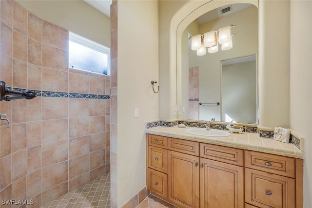 bathroom with vanity and tiled shower