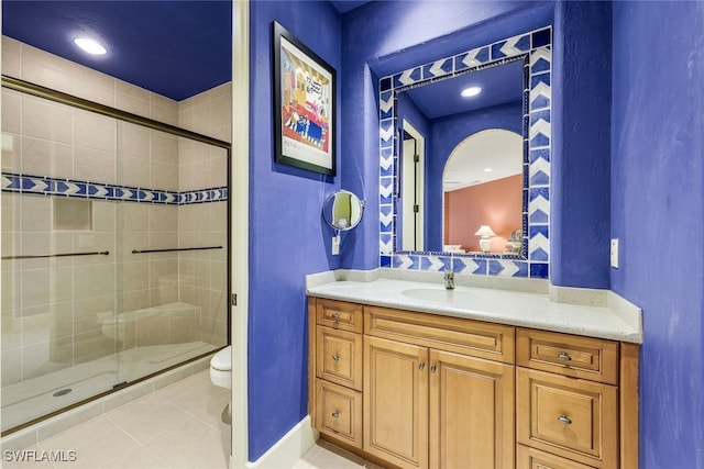 bathroom with tile patterned floors, vanity, toilet, and walk in shower