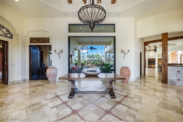 entryway featuring a notable chandelier, a towering ceiling, sink, and a wealth of natural light