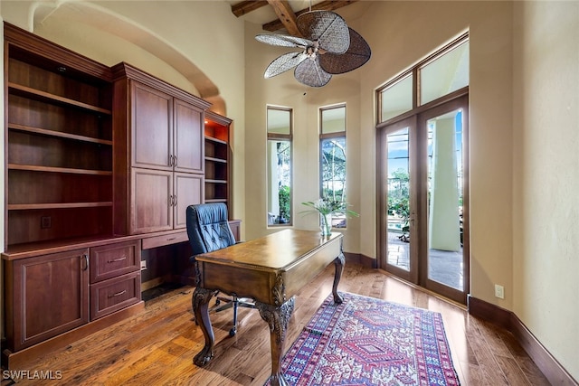 office area featuring ceiling fan, beam ceiling, french doors, and light hardwood / wood-style flooring