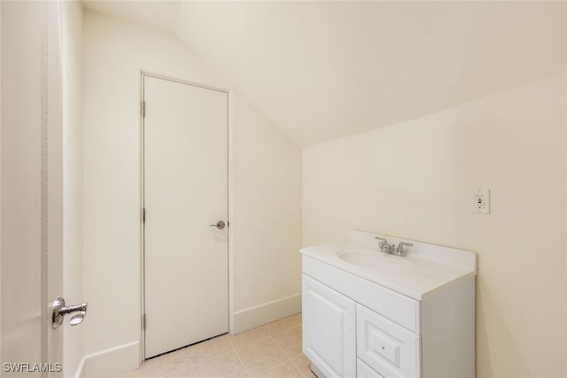 bathroom with tile patterned flooring, vanity, and vaulted ceiling