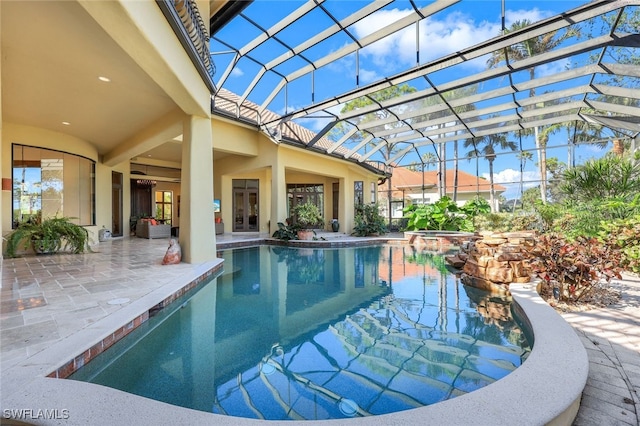 view of swimming pool with a patio area, ceiling fan, and a lanai