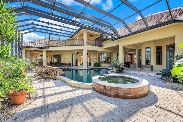 view of pool featuring glass enclosure, an in ground hot tub, a patio area, and ceiling fan