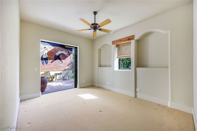 carpeted spare room featuring ceiling fan