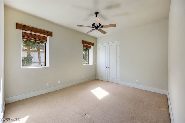 unfurnished bedroom with multiple windows, ceiling fan, a closet, and light colored carpet