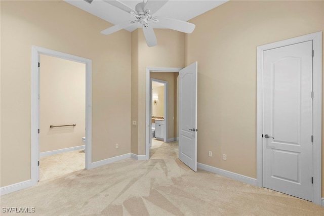 unfurnished bedroom with light carpet, ensuite bathroom, and ceiling fan