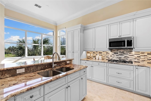 kitchen with white cabinets, crown molding, sink, and appliances with stainless steel finishes