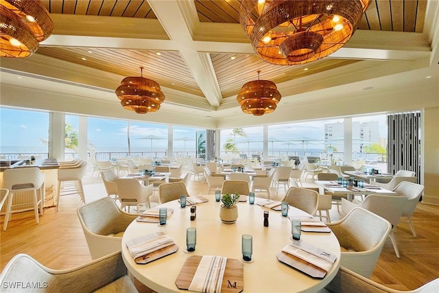 dining space with wooden ceiling, coffered ceiling, beamed ceiling, a notable chandelier, and light hardwood / wood-style floors