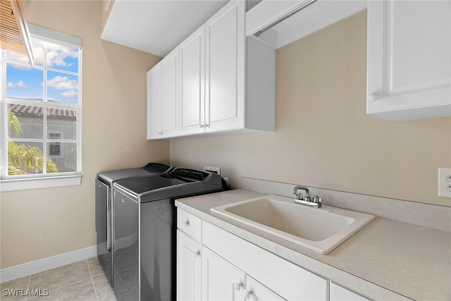 washroom featuring cabinets, light tile patterned floors, sink, and washing machine and clothes dryer