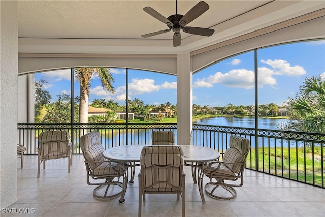 sunroom / solarium featuring ceiling fan and a water view