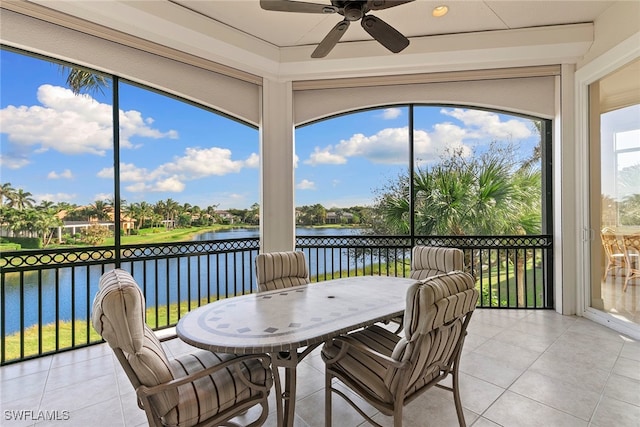 sunroom / solarium with ceiling fan and a water view