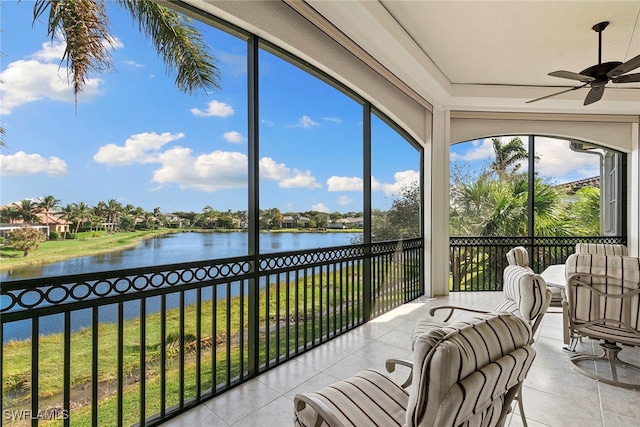 sunroom / solarium with ceiling fan and a water view