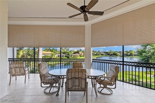 sunroom featuring a water view and ceiling fan